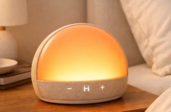 Hatch Restore 3 sunrise alarm clock glowing warm orange on bedside table