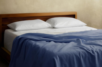 Sleep and Beyond organic cotton honeycomb blanket in Pacific Blue draped on bed