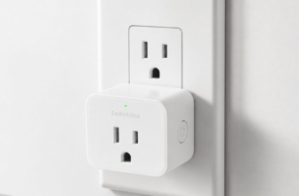 SwitchBot Plug Mini smart plug installed in a US wall outlet near a white noise machine