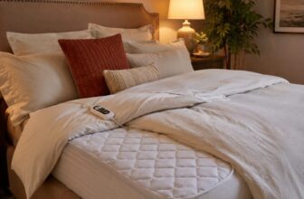 Cozy bed with a quilted heated mattress pad corner folded back and a heat controller remote