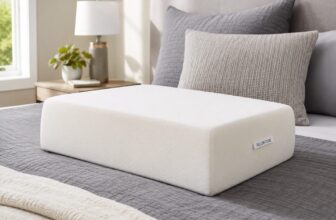 Pillow Cube white cube-shaped side sleeper pillow on a bed with gray bedding