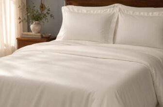 Ivory organic cotton sateen duvet cover and pillow shams on a made bed in soft morning light